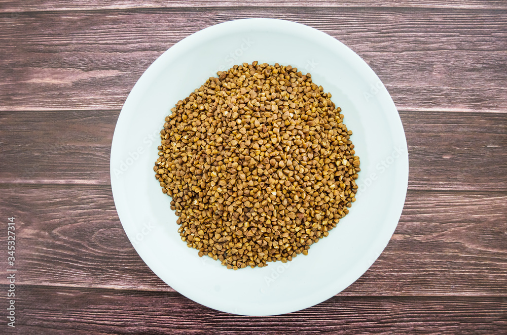 buckwheat in a plate on a wooden background. buckwheat in a plate on a wooden background.