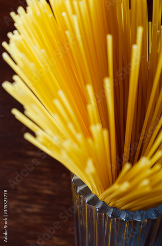 Spaghetti in a glass cup on a brown wooden table photo