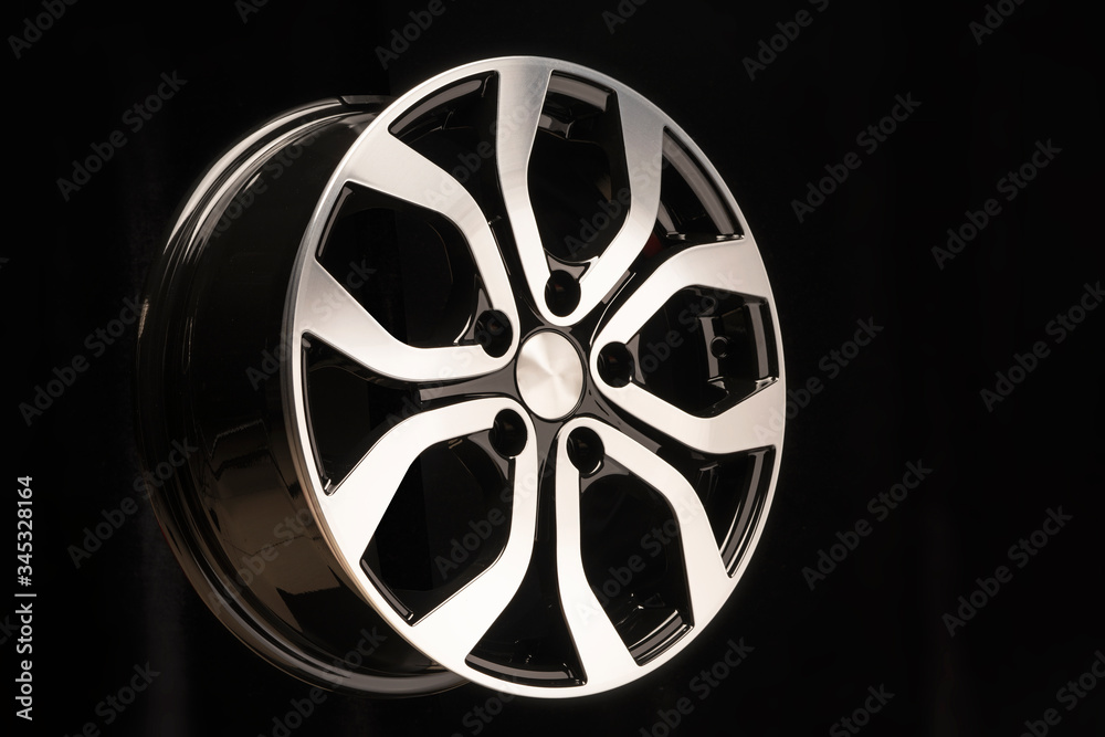 New alloy wheel of the car, close-up on a black background, wheel elements, two-color coating, shiny. left location on the layout