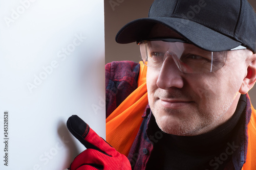 A man in work gloves points...