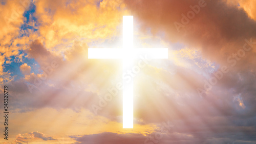 The Christian cross among the clouds. Religion. Support of the faithful. Religious signs and symbols. Light pours from the cross in the sky.