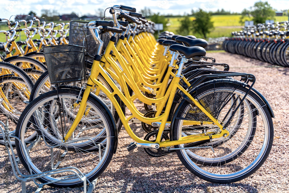 Row of bicycles parked. Yellow bicycles stand on a parking for rent.To save energy and environmentally friendly. Selective focus. Row of bicycles parked. Yellow bicycles stand on a parking for rent.To save energy and environmentally friendly. Selective focus.