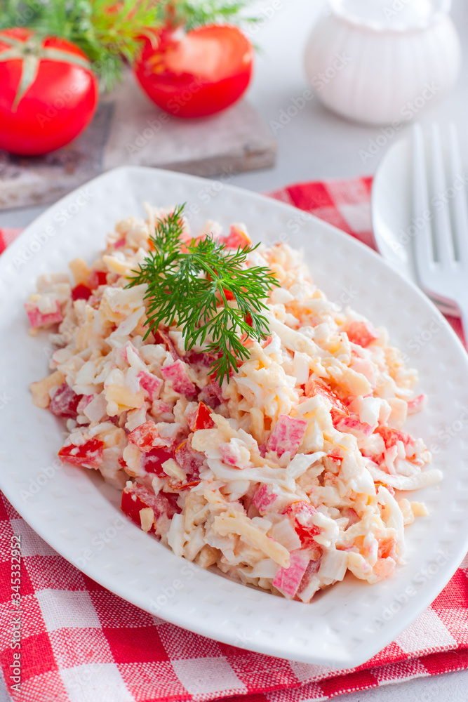 salad with crab sticks, tomatoes, cheese on a white dish, selective focus salad with crab sticks, tomatoes, cheese on a white dish, selective focus