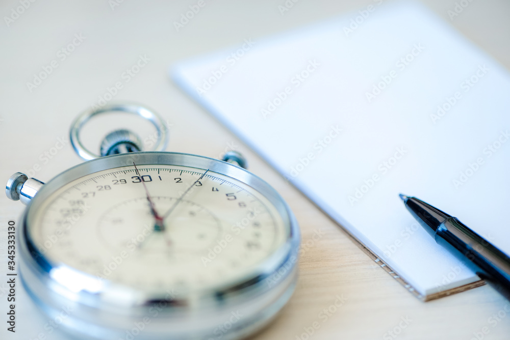 Notepad, pen And Stopwatch biege on desk wooden background. The concept of time management Notepad, pen And Stopwatch biege on desk wooden background. The concept of time management