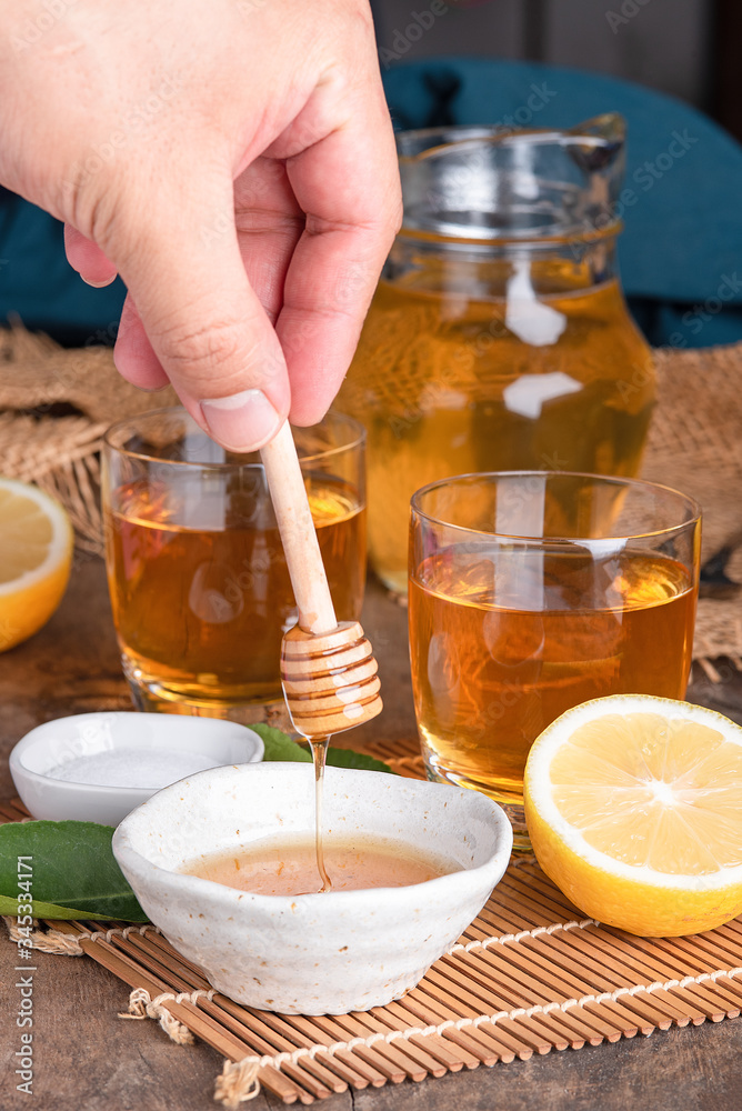 A glass of iced tea with mint and lemon on a wooden table.A glass cup of tea with lemon, mint, and honey on a wooden rustic table. A glass of iced tea with mint and lemon on a wooden table.A glass cup of tea with lemon, mint, and honey on a wooden rustic table.