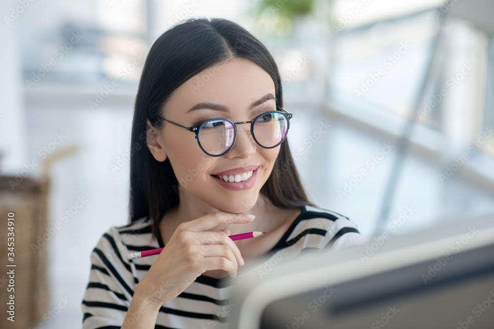 Obraz premium Dark-haired pretty woman in eyeglasses looking happy
