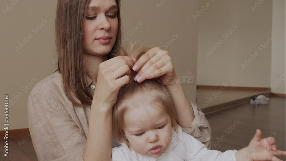 Young mother daughter. Caring mom makes cute pony tail to her little girl. Family together. Young mother daughter. Caring mom makes cute pony tail to her little girl. Family together.
