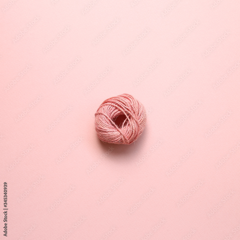 Pink string roll on pink background. top view