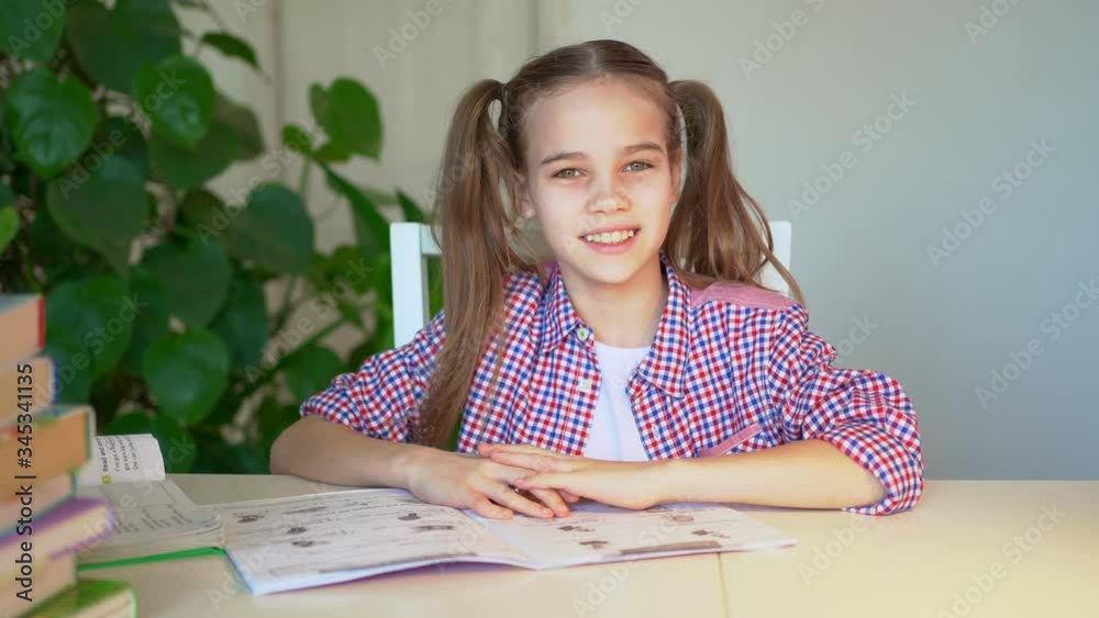 schoolgirl in a plaid shirt doing homework schoolgirl in a plaid shirt doing homework