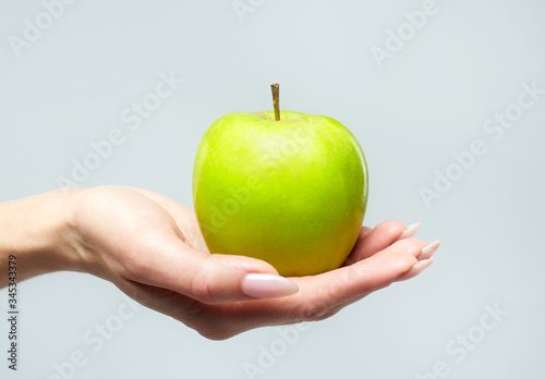 the green Apple is in the girl's palm