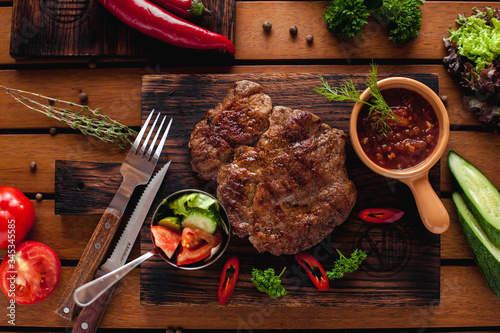 Beef steak with chilli on a wooden table.