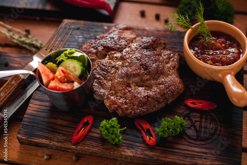 Beef steak with chilli on a wooden table.