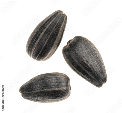 Close-up of three delicious sunflower black seeds, isolated on white background