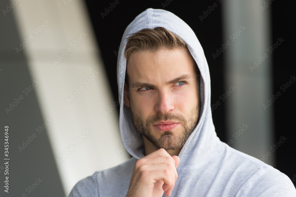 Naklejka premium His beard is unshaven. Unshaven man in hood outdoors. Handsome guy with unshaven face. Bachelor wear hoodie. Unshaven look. Barbershop. Hair salon. Mens grooming habit. Sexy boy