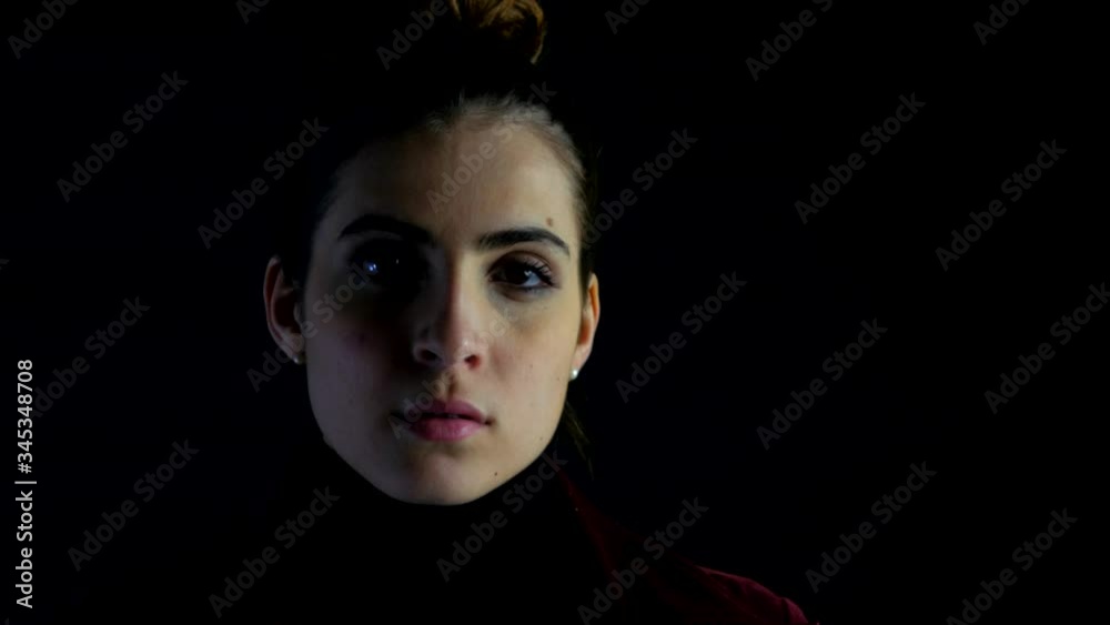 Woman in black background strong intense serious expression during quarantine coronavirus Woman in black background strong intense serious expression during quarantine coronavirus