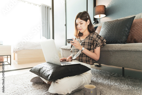 Free Download Young Asian woman using credit card for shopping online at her home - GFXLoad