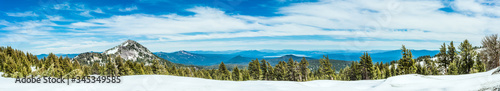 Mountains, lakes, and a forest with snow - photographed as a wide panorama at Lassen Volcanic National Park in Northern California