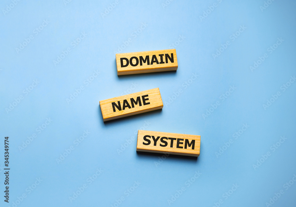 DNS - Domain Name System, acronym technology concept on wooden blocks on blue. DNS - Domain Name System, acronym technology concept on wooden blocks on blue.