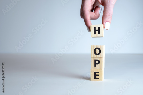 Concept image of Business Acronym HOPE as HAVE ONLY POSITIVE EXPECTATIONS written on wooden cubes.
