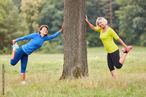 Two senior women do a stretching exercise