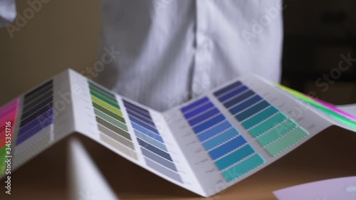 designer unfolds a palette on cardboard for color matching