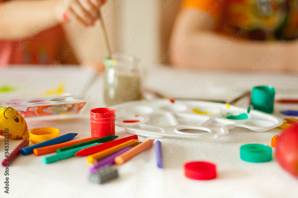 A kids drawing with colored paints on the papers. A kids drawing with colored paints on the papers.