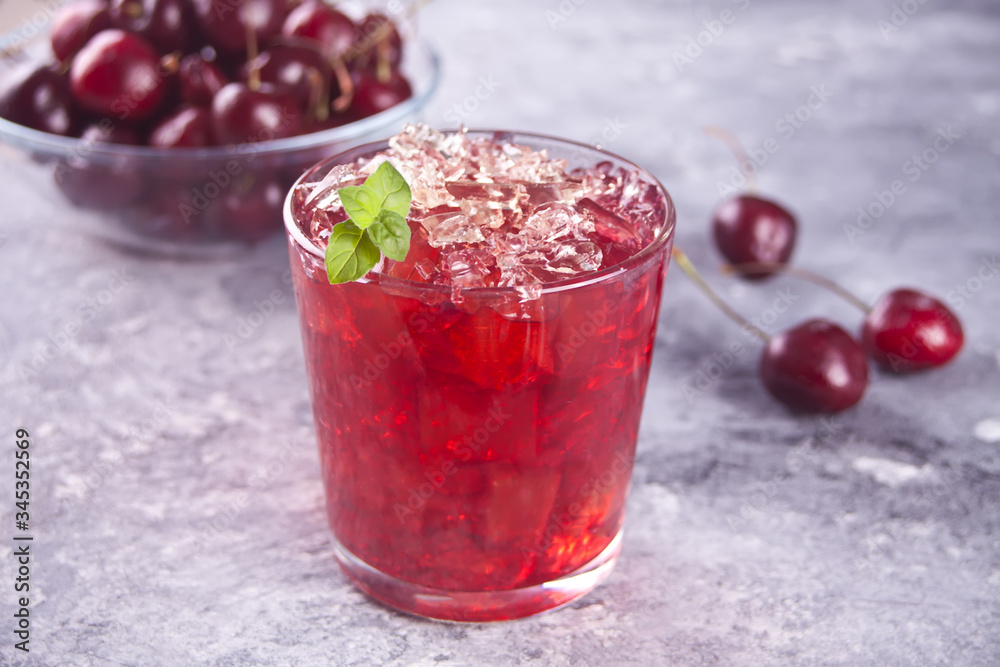 Glass with fresh homemade cherry sweet iced tea or cocktail, lemonade with mint. Refreshing cold drink. Summer party. Glass with fresh homemade cherry sweet iced tea or cocktail, lemonade with mint. Refreshing cold drink. Summer party.