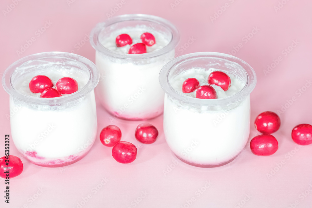 jars of yogurt, berry jam and ripe berries close-up. background with berry yogurt and cranberries. jars of yogurt, berry jam and ripe berries close-up. background with berry yogurt and cranberries.
