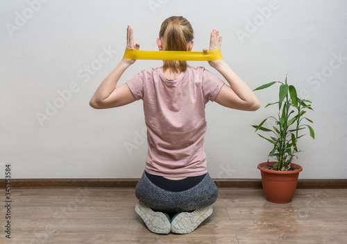 girl doing fitness at home, with dumbbells and a sports tape photo