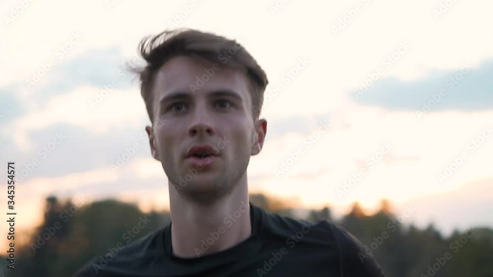 Exhausted young athlete exercising endurance run with Hair in the wind during sunset, close up, slow motion Exhausted young athlete exercising endurance run with Hair in the wind during sunset, close up, slow motion