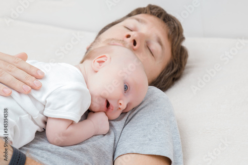 Infant lying on father breast and relaxing together. Lovely, emotional moment. Closeup