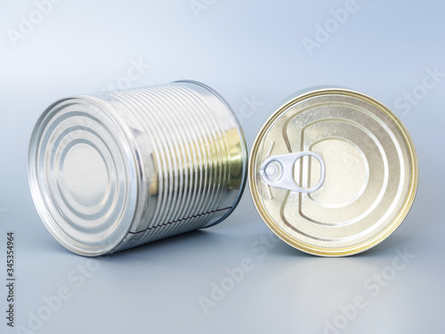 Many tin cans of gold and silver color, isolated on a gray background, top view, copispace, mockup. Concept: food delivery, food products, donations, during the coronavirus quarantine period