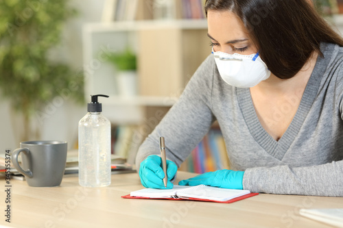 Woman taking notes on agenda avoiding covid-19 at home