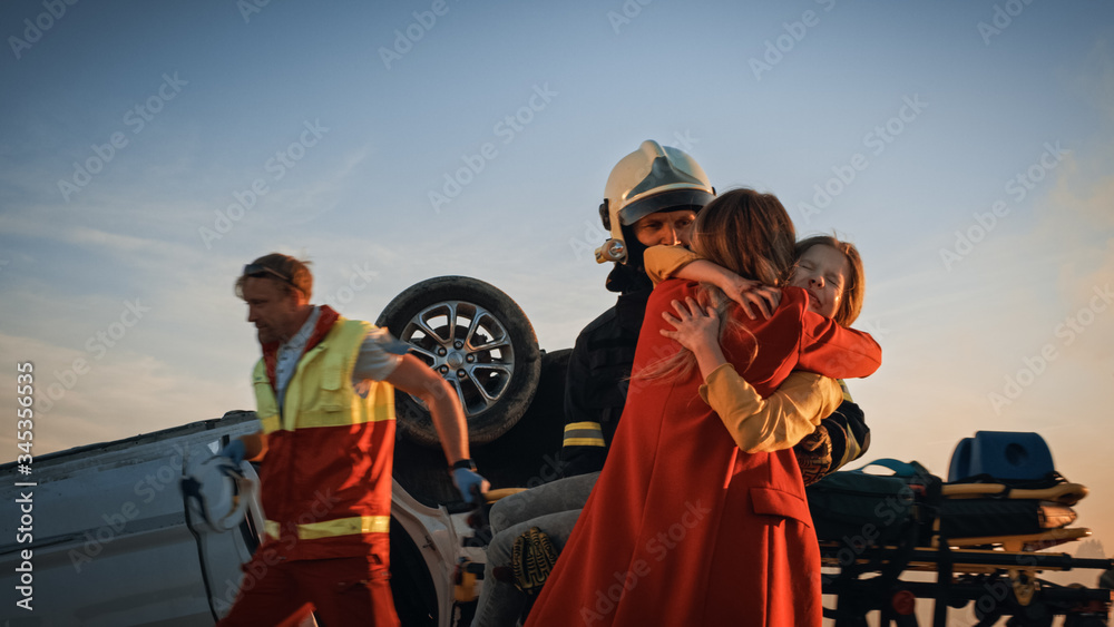 Shot of Sweet Mother Hugging Her Young Daughter Victims of Some Terrible Accident. In the Background Car Crash Traffic Accident Courageous Paramedics and Firemen Save Lives