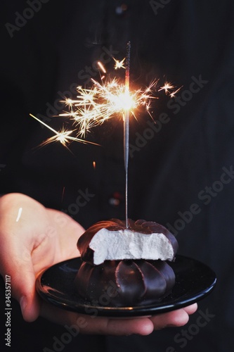 Obraz na płótnie Chocolate marshmallows with sparklers, design food, dark mood on black background w salonie