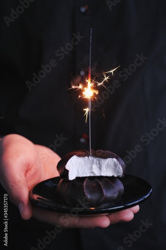 Obraz na płótnie Chocolate marshmallows with sparklers, design food, dark mood on black background w salonie