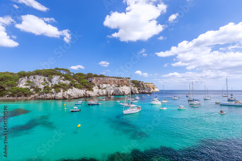 View of the most beautiful bay Cala Macarella of the island Menorca with emerald water and a lot of yachts on the sea. Balearic islands, Spain © Artem