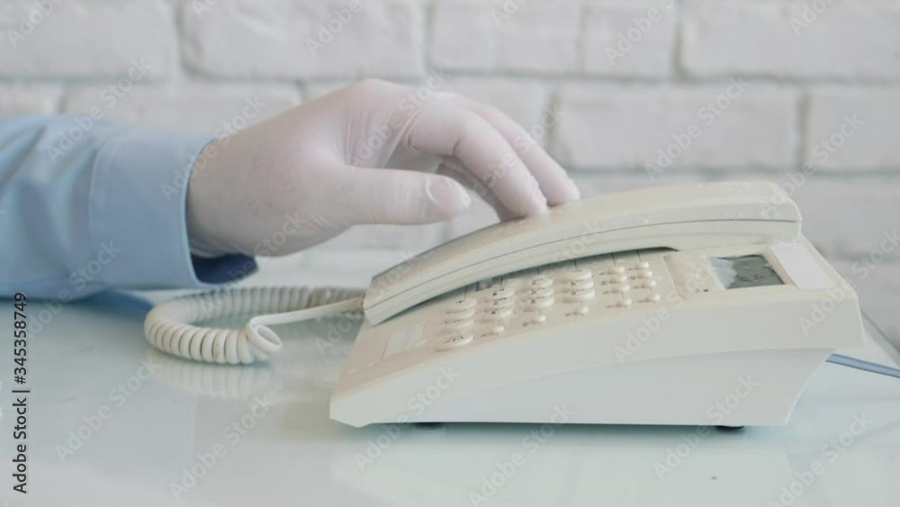 Man with Protection Gloves in Hands Cleaning and Disinfecting a Telephone Using a Spray and Wet Wipes Man with Protection Gloves in Hands Cleaning and Disinfecting a Telephone Using a Spray and Wet Wipes