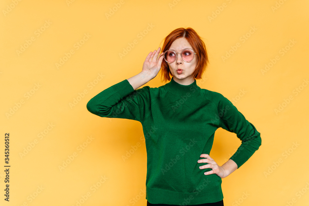 Surprised excited woman on yellow background. Cheerful multiracial female model joyful wearing sun glasses