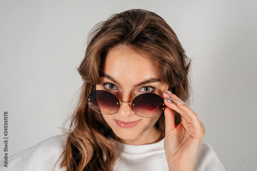 Beautiful young woman with big black glasses-close up portrait on white background Beautiful young woman with big black glasses-close up portrait on white background