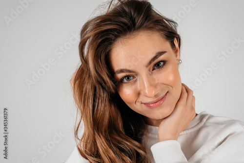 Young beautiful woman portrait isolated on white background. Happy girl close up face looking to the camera
