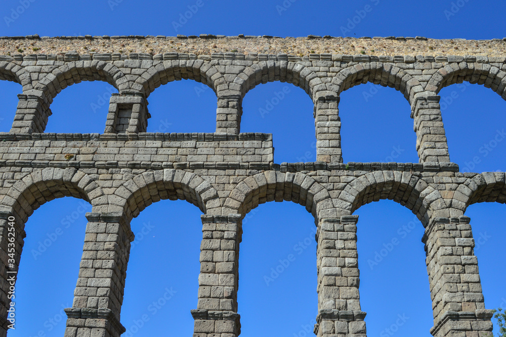 view of the aqueduct cut out against blue sky in Segovia. Spain