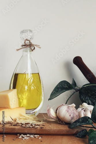 Obraz na płótnie Art composition, design food - oil, garlic, spices and cheese on wooden table and white background w salonie