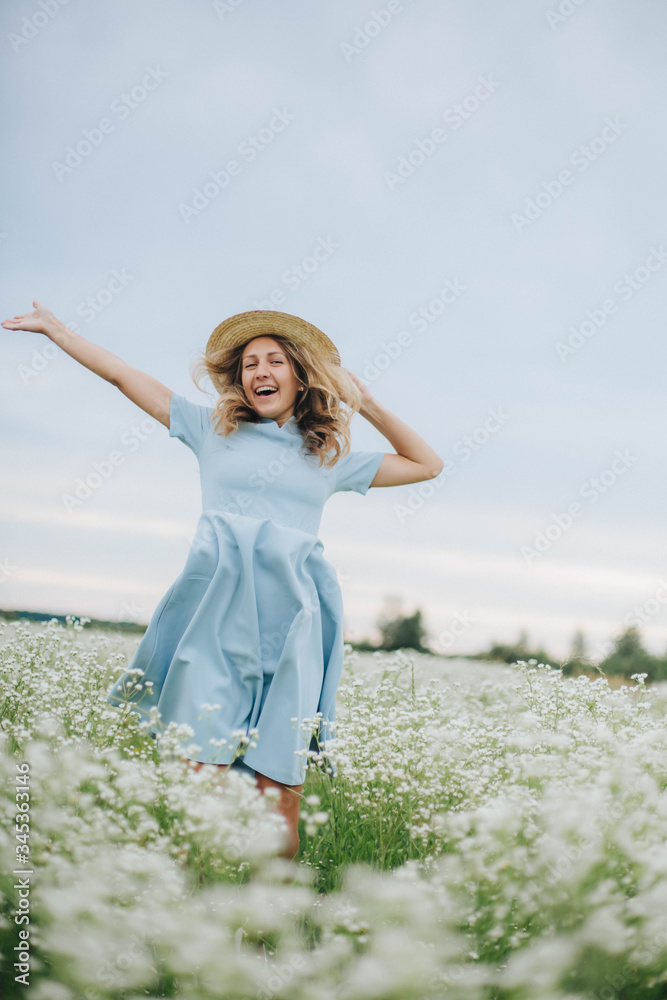 beautiful blonde girl in a field of daisies. wreath of wildflowers on his head. woman in a blue dress in a field of white flowers. charming girl with a bouquet of daisies. summer tender photo beautiful blonde girl in a field of daisies. wreath of wildflowers on his head. woman in a blue dress in a field of white flowers. charming girl with a bouquet of daisies. summer tender photo