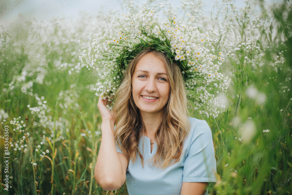 beautiful blonde girl in a field of daisies. wreath of wildflowers on his head. woman in a blue dress in a field of white flowers. charming girl with a bouquet of daisies. summer tender photo beautiful blonde girl in a field of daisies. wreath of wildflowers on his head. woman in a blue dress in a field of white flowers. charming girl with a bouquet of daisies. summer tender photo