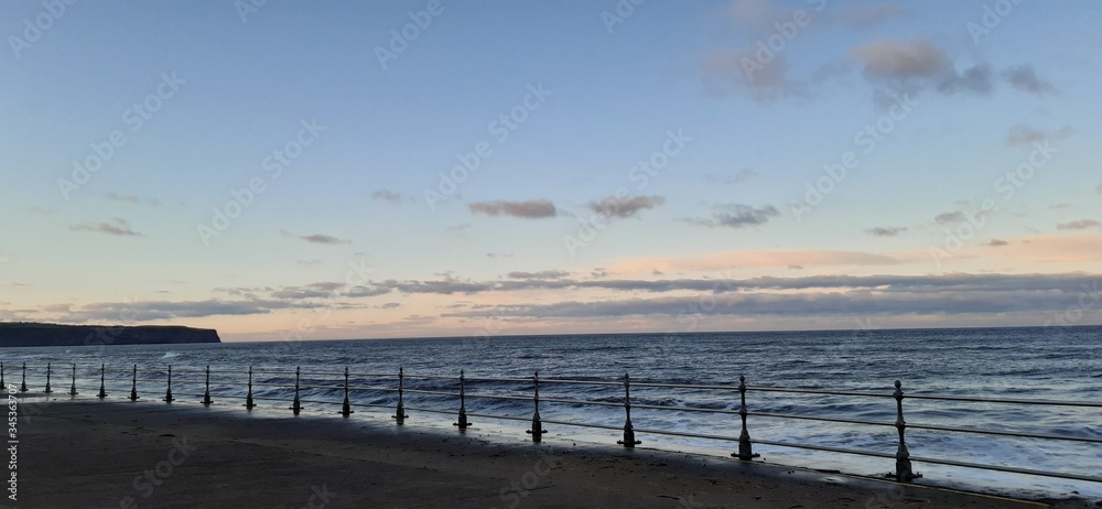 Concrete railed promenade along Whitby beach at sunset Concrete railed promenade along Whitby beach at sunset