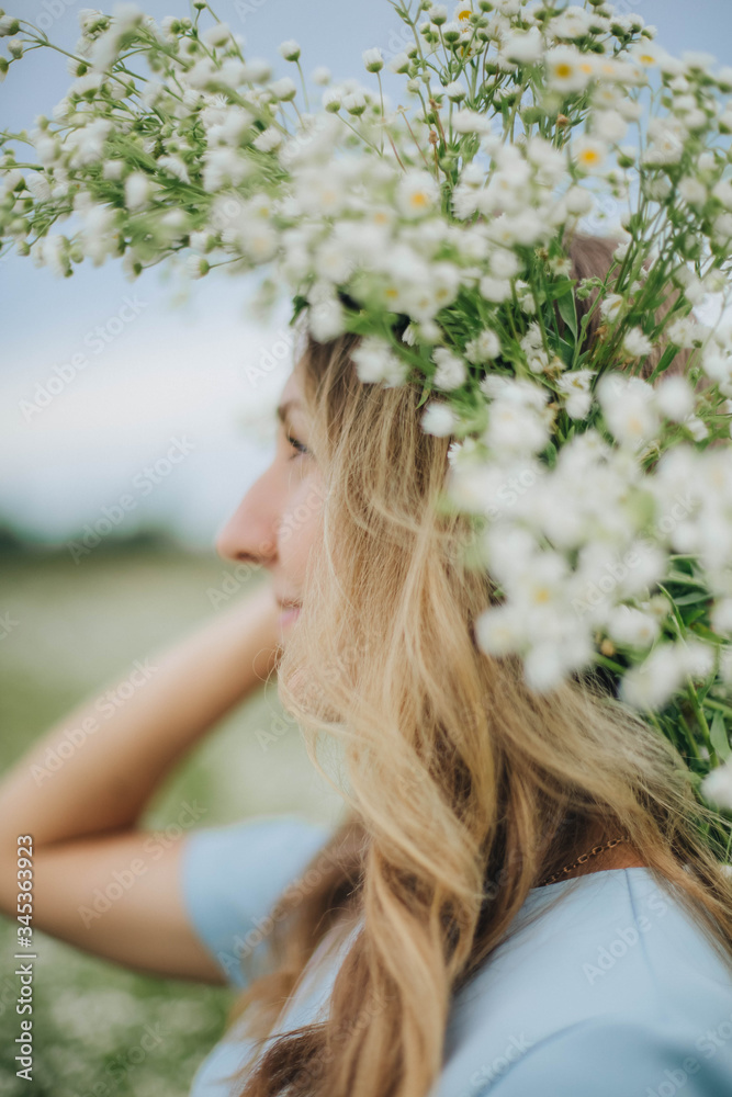 beautiful blonde girl in a field of daisies. wreath of wildflowers on his head. woman in a blue dress in a field of white flowers. charming girl with a bouquet of daisies. summer tender photo beautiful blonde girl in a field of daisies. wreath of wildflowers on his head. woman in a blue dress in a field of white flowers. charming girl with a bouquet of daisies. summer tender photo