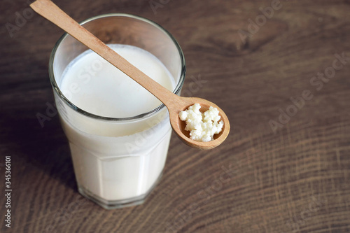 Kefir grains and kefir drink on wooden background photo