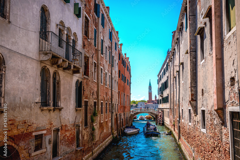 Venetian canal, old buildings and medieval bridges .