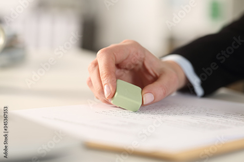 Business woman hand erasing form with rubber at the office